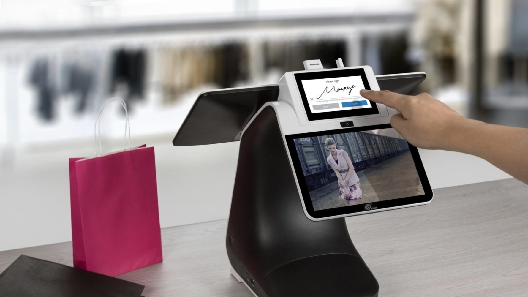 Customer signing on the dual-screen Elegant POS terminal at a boutique checkout counter